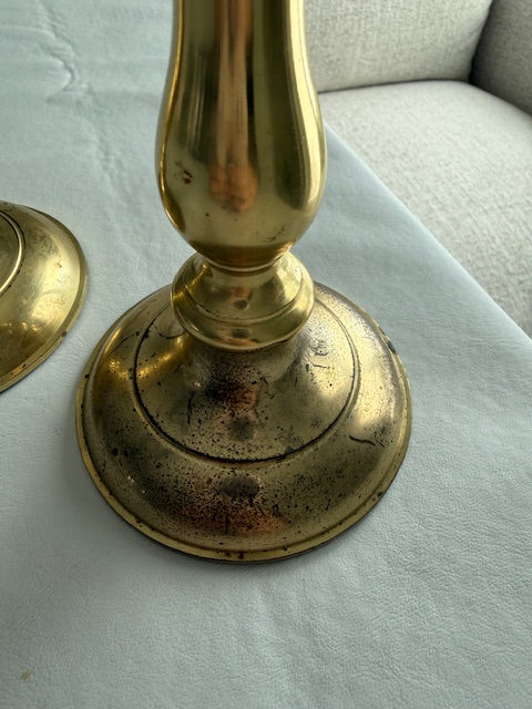 Solid brass taper candle holders with spindle stem and circular base.