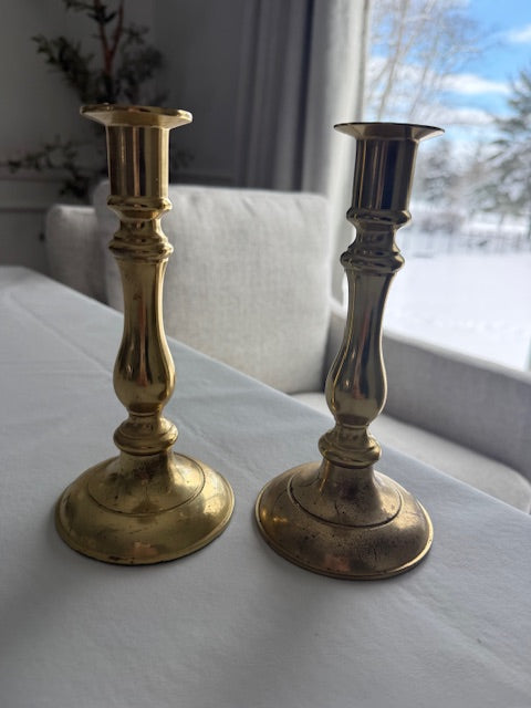 Solid brass taper candle holders with spindle stem and circular base.