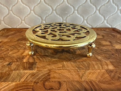 Baldwin solid brass trivet on feet.